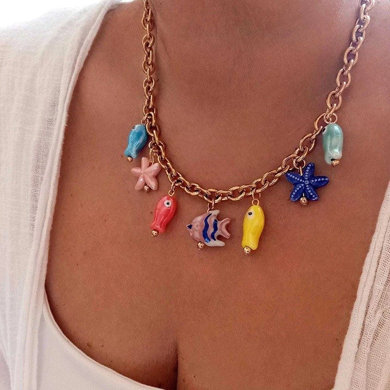 woman turned to her side wearing ceramic colorful fish necklace