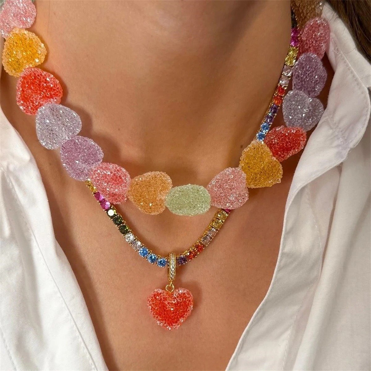 woman wearing colorful candy necklace, necklace with heart and a white button shirt