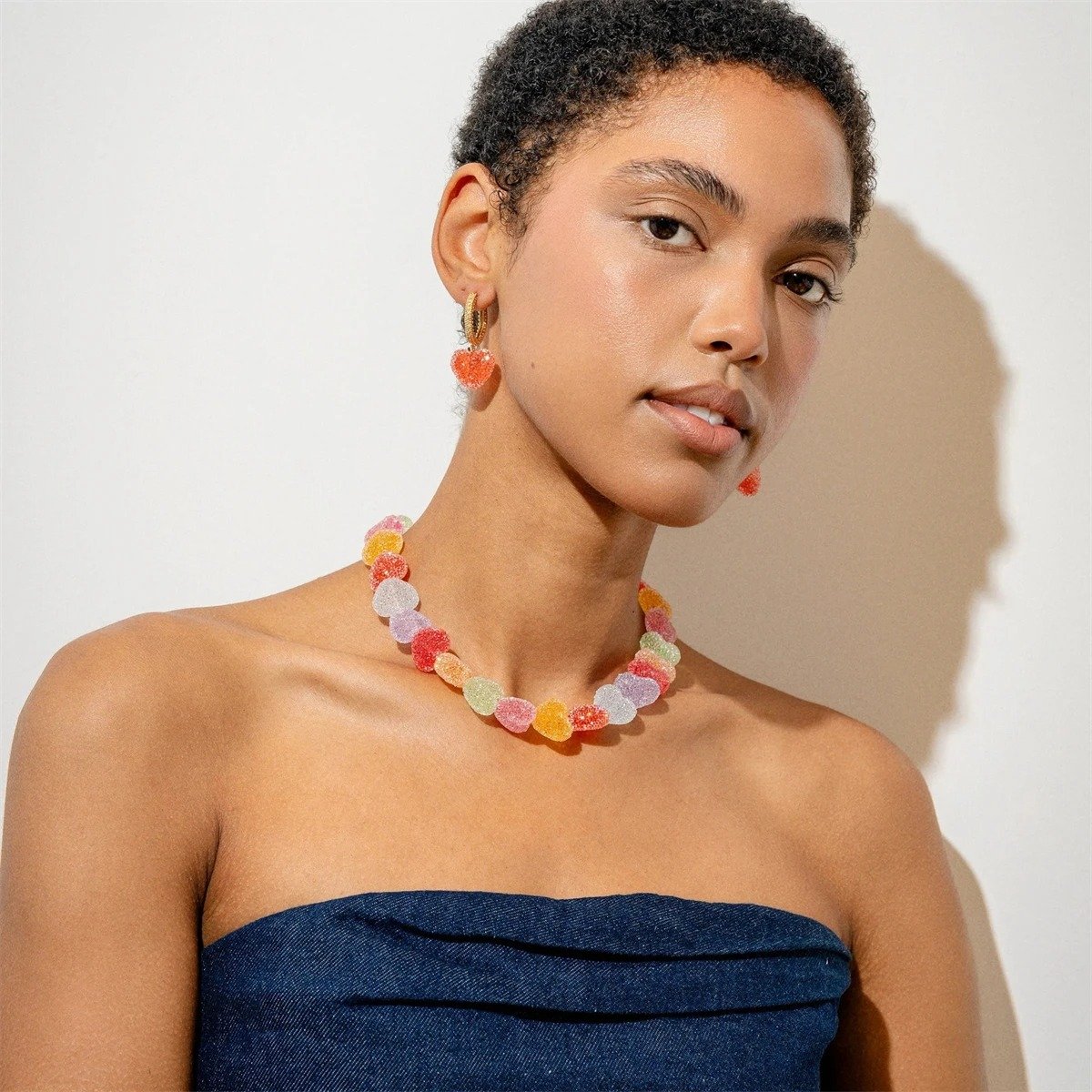 woman with short dark brown hair wearing colorful candy necklace