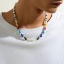 woman wearing colorful necklace with peal imitation on a white shirt