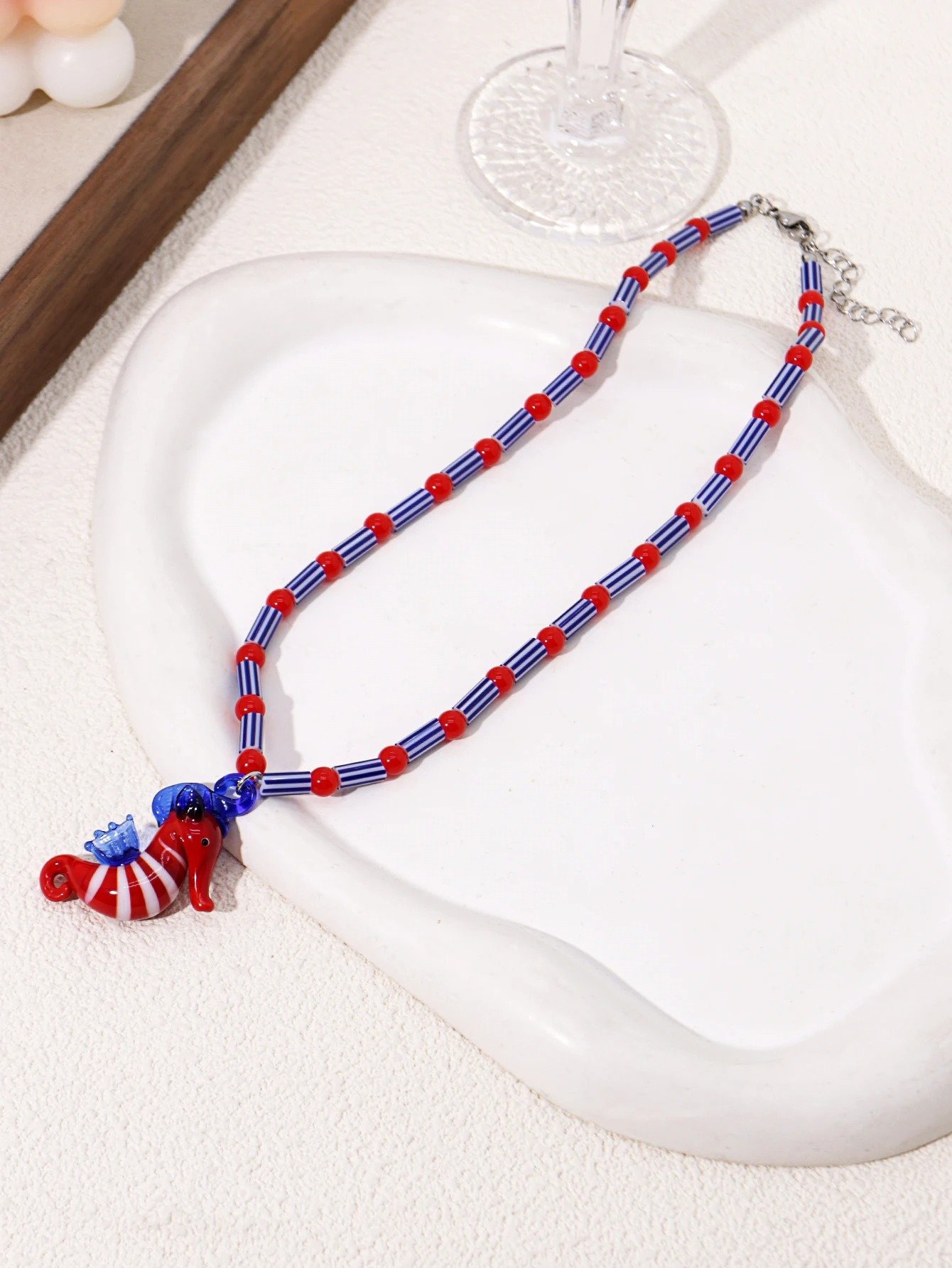 colorful seahorse necklace on the white silky fabric