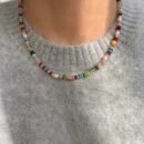 woman wearing retro colorful necklace and a grey sweater