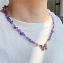woman wearing purple necklace on a a white shirt