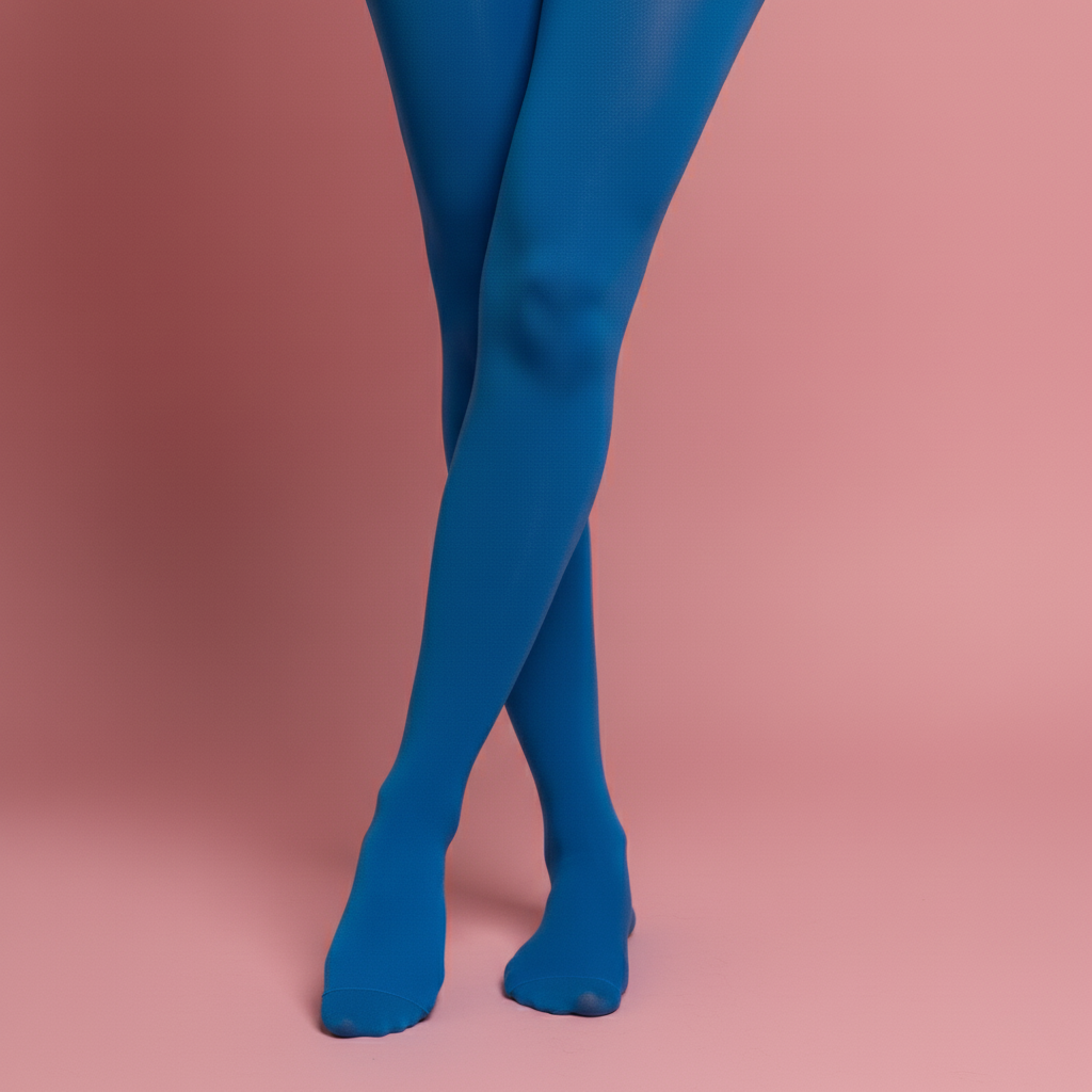 A low-angle close-up shot of a person's legs, crossed at the ankles, wearing bright blue tights. Their feet are visible on a solid pink background.