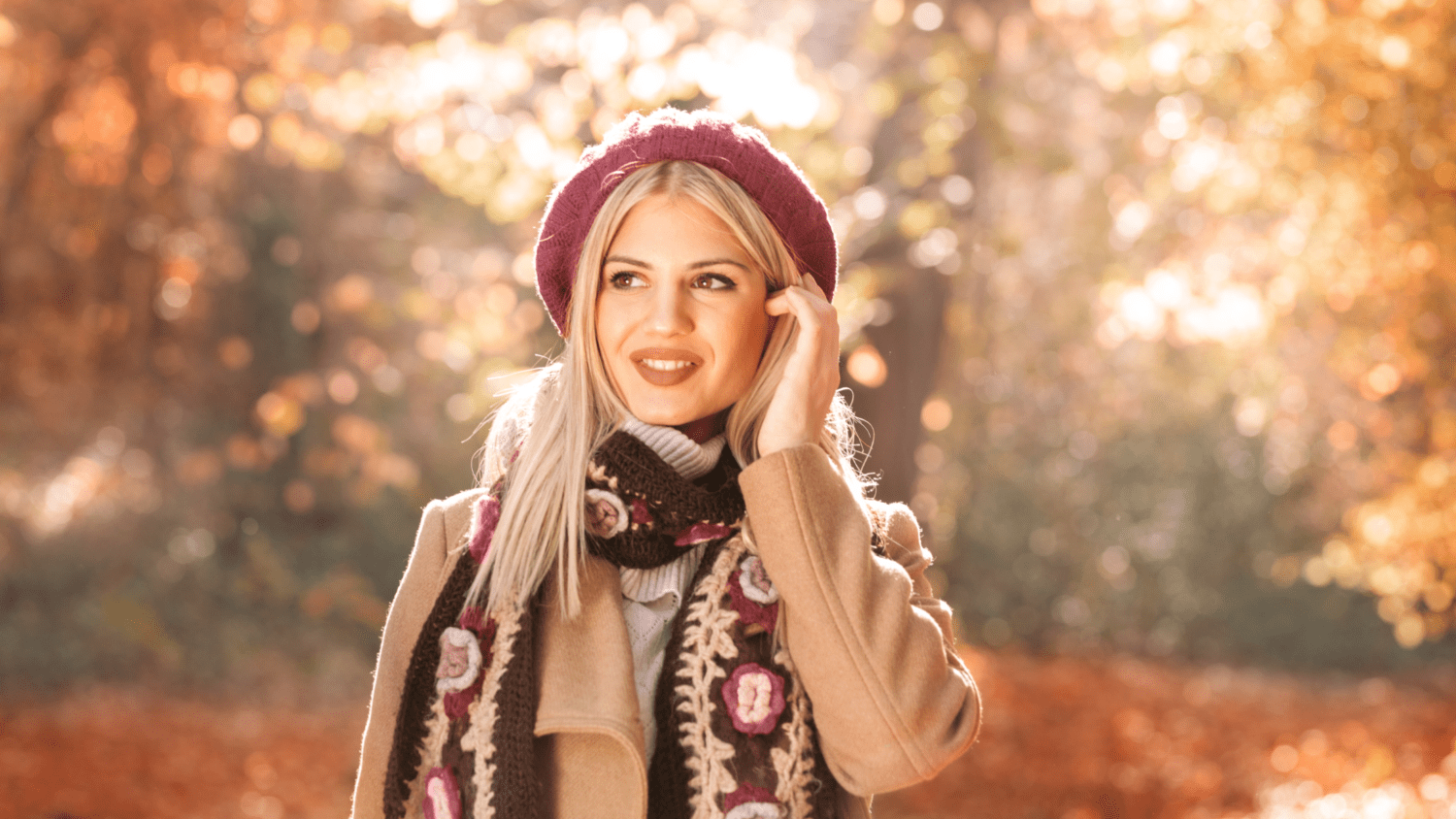 woman wearing a beret and an autumn coat over a cardigan showing how to style a colorful cardigan in the park